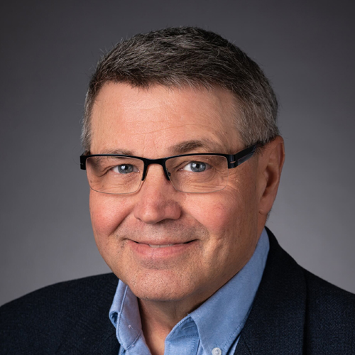Man wearing glasses in blue suit and tie